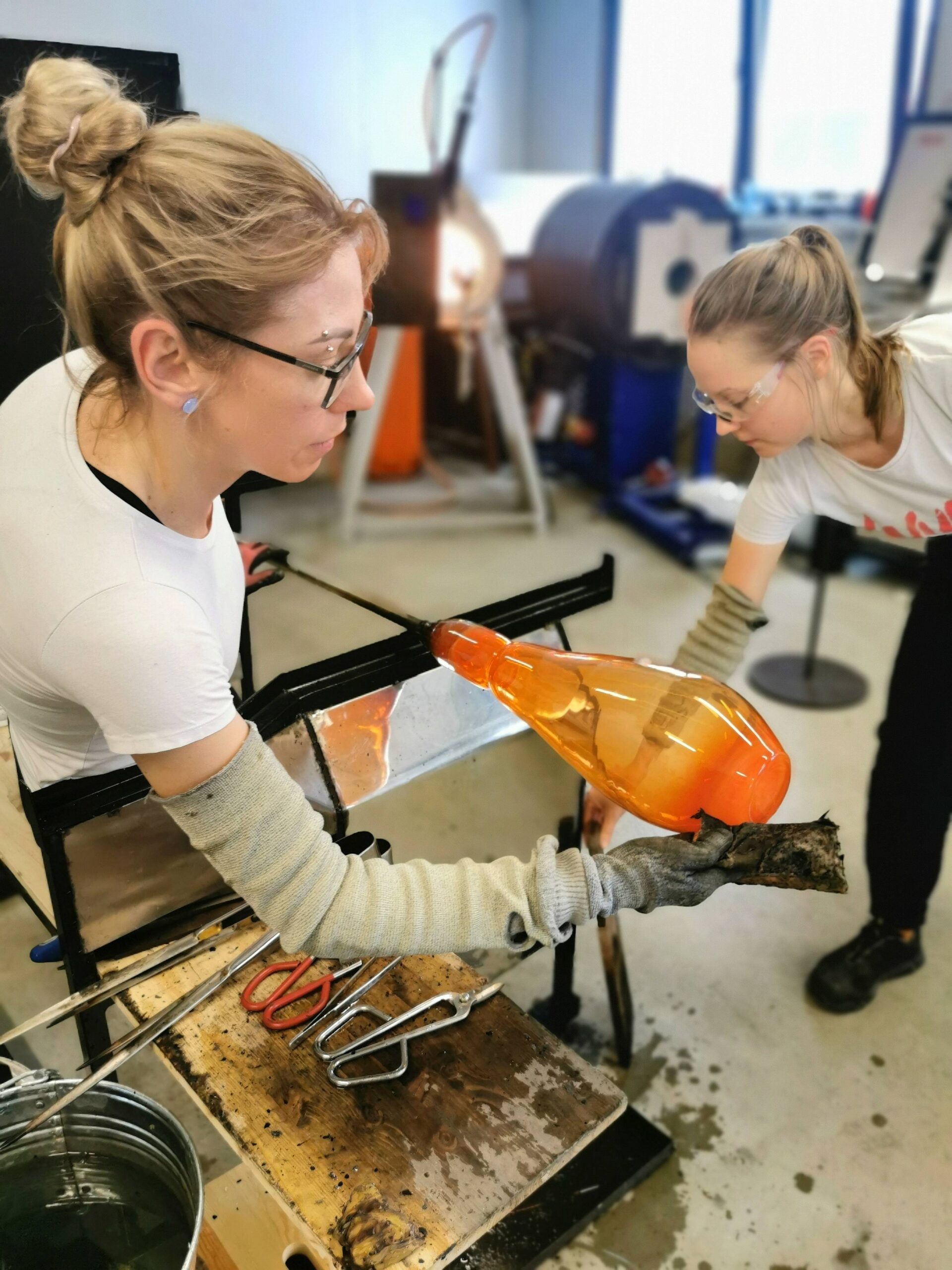 Finishing the bottom of a mold-blown vase using wet newspaper.